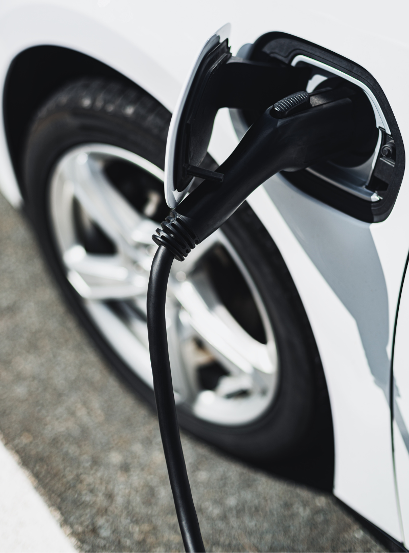An electric car is charging at a station. We offer EV charging station installation