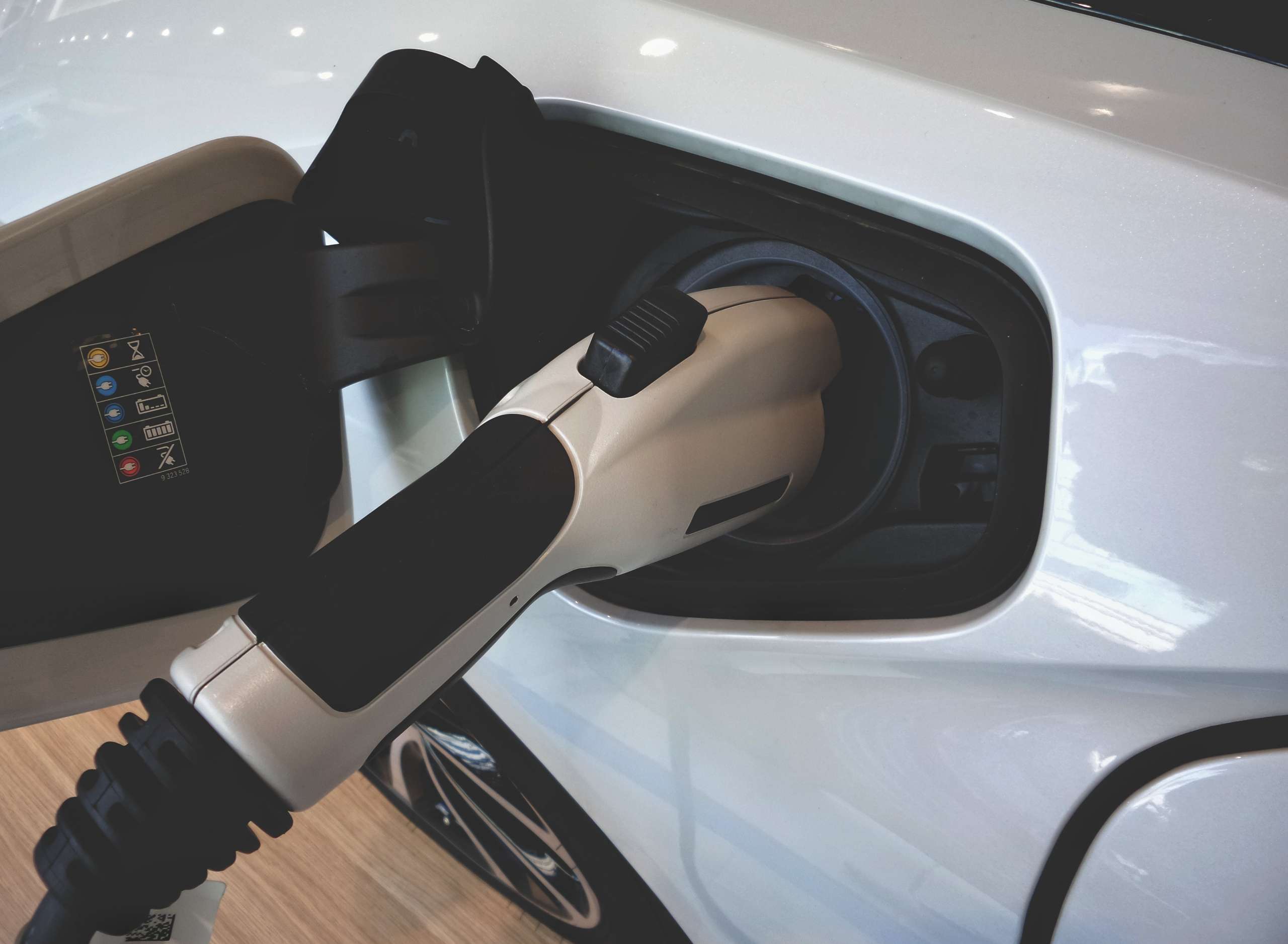 An electric car is charging at a station. We offer EV charging station installation